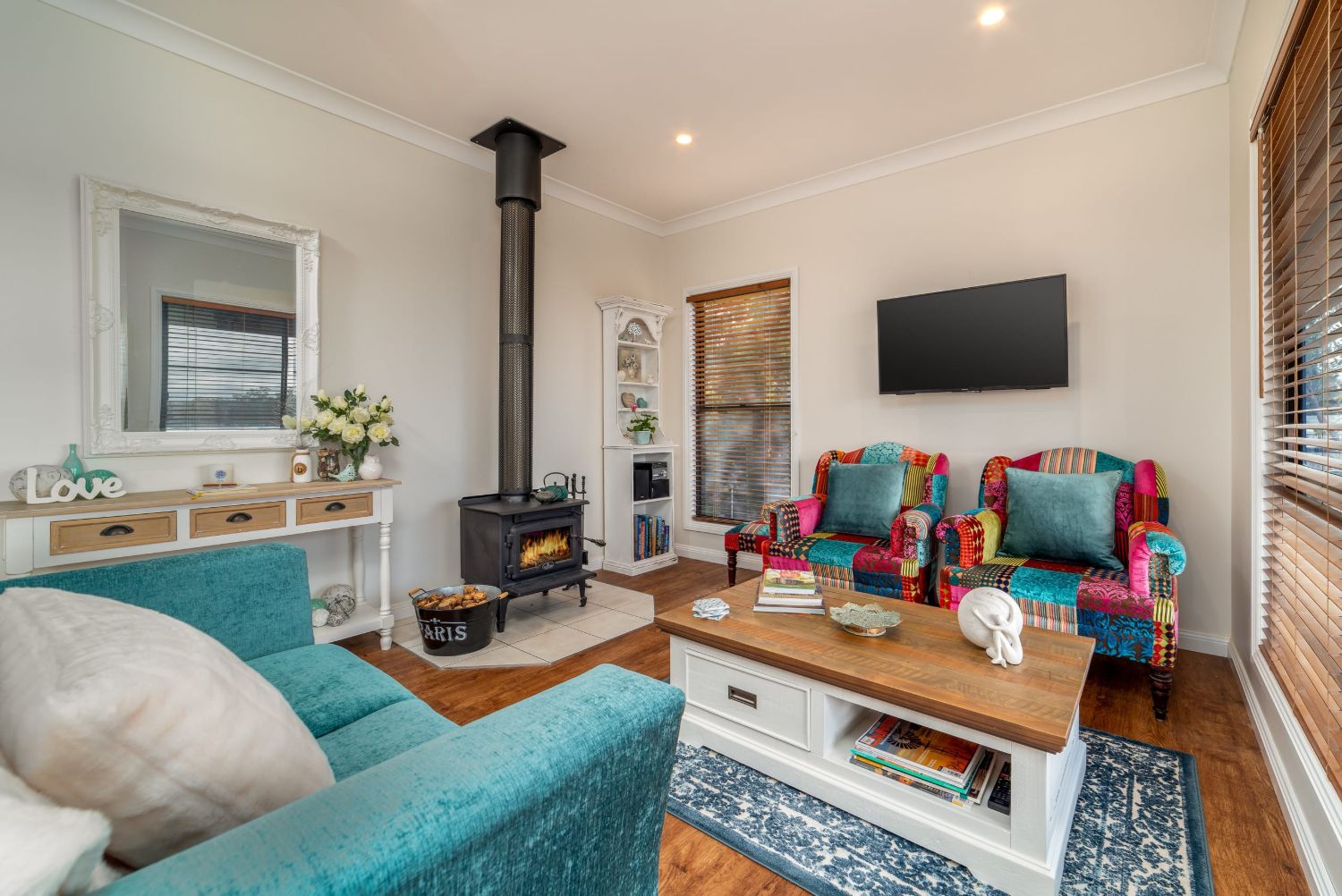 The living room, patchwork armchairs and a wall of windows onto the deck