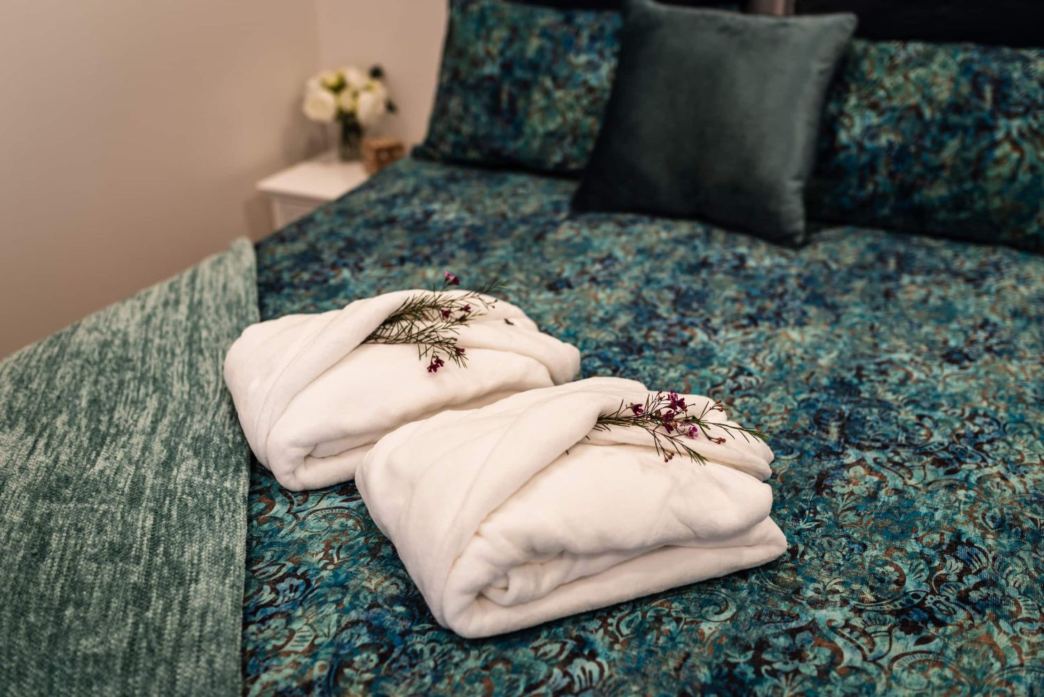 The main bedroom, queen bed with plush robes laid out