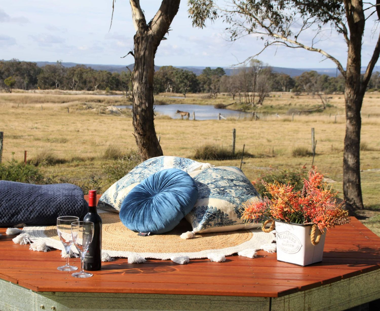The fire pit and its curved stone bench, wood stacked ready
