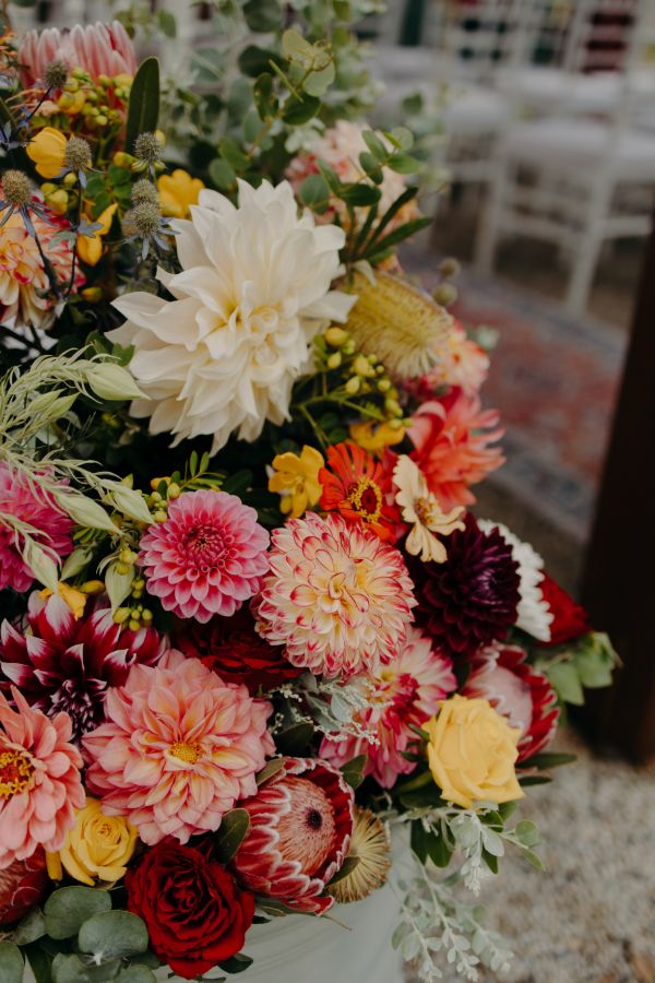 Poppies, roses and proteas with eucalyptus against granite