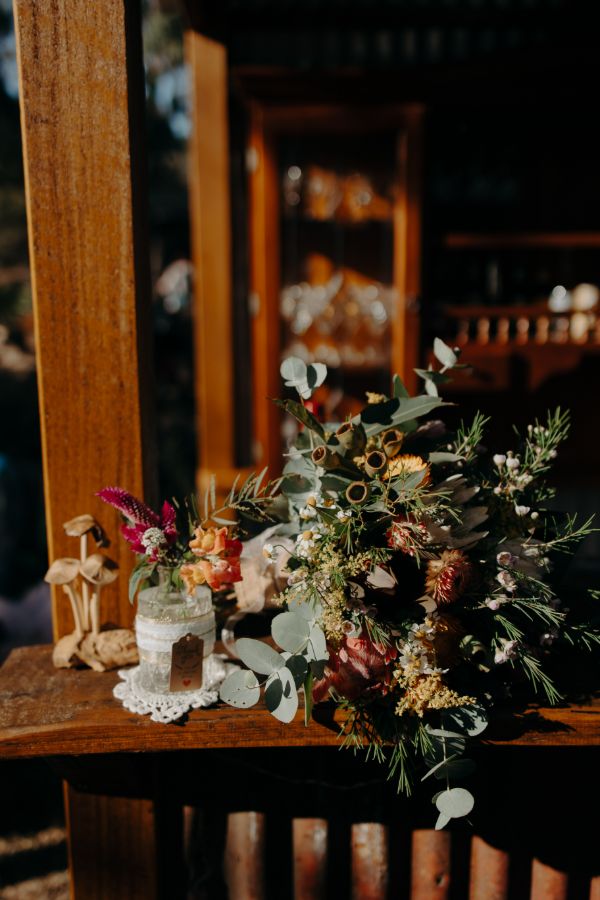 Bridal shoes, veil and a native bouquet on a gold velvet chair