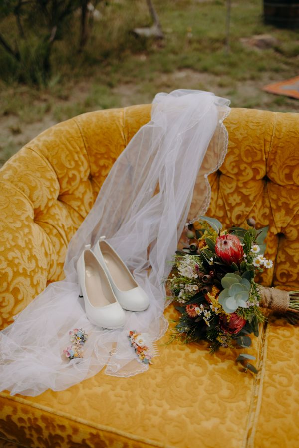 A ceremony urn of dahlias and proteas by the aisle